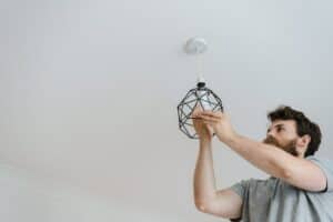 Man changing electrical bulb at home