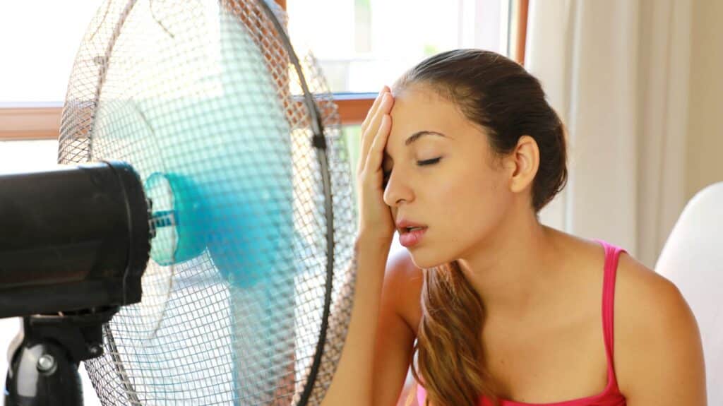 unhappy woman with noisy fan in heat